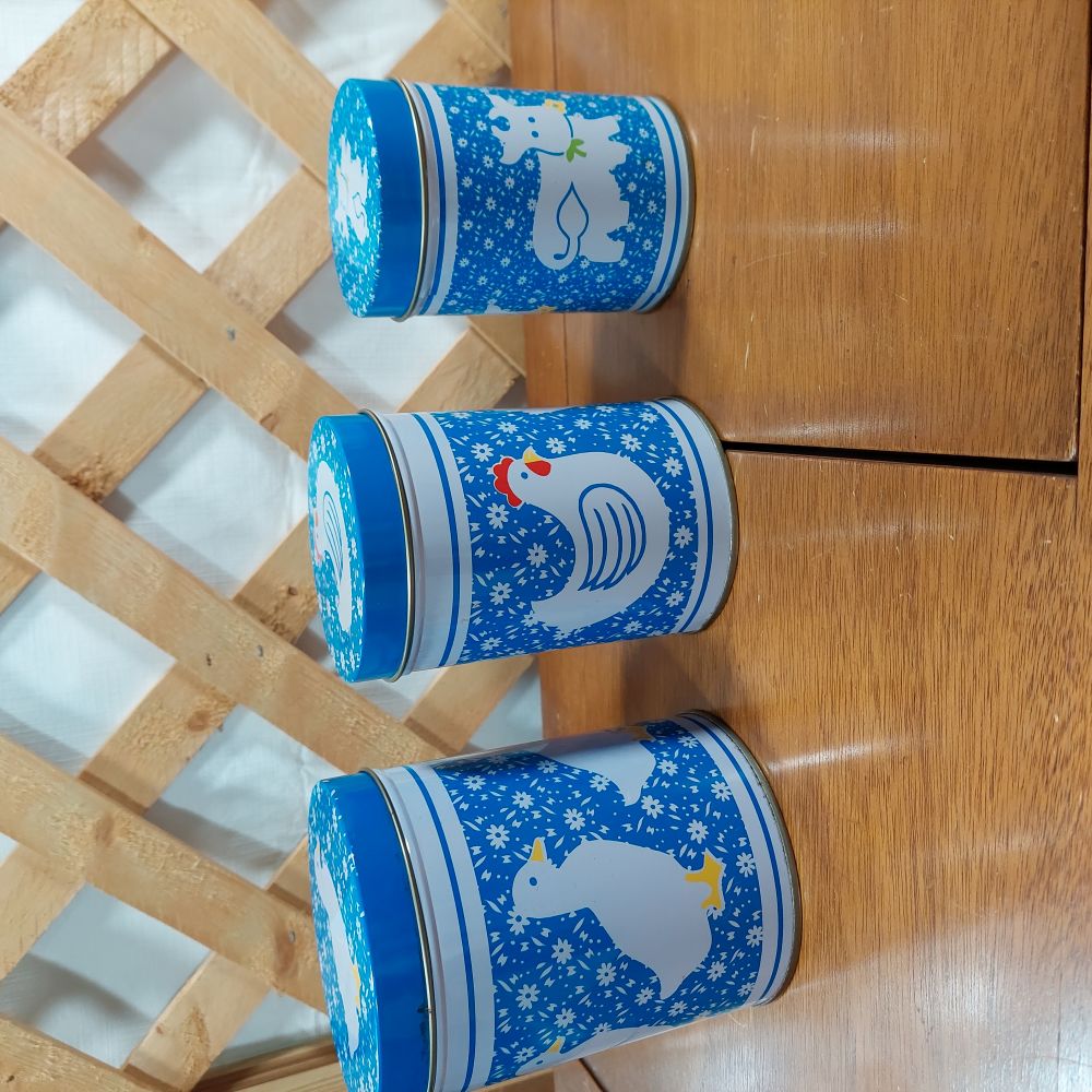 Farm Animals Tin Nesting Canister Set of 3 graduated sizes, featuring a duck, chicken and cow. Great for storage and organizing in the kitchen, gives a "country kitchen" feel.