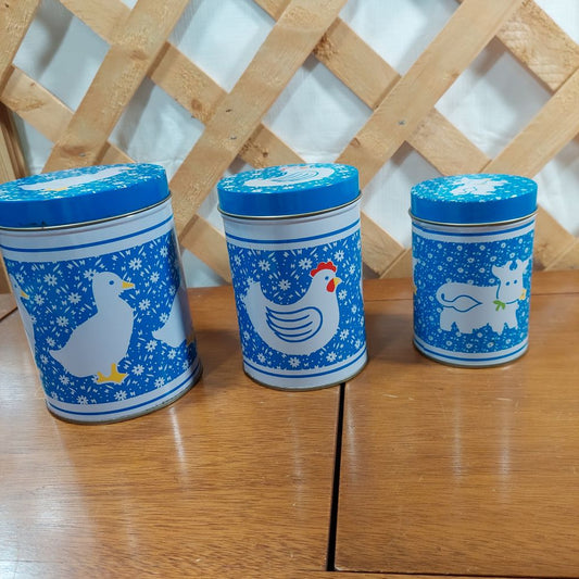 Farm Animals Tin Nesting Canister Set of 3 graduated sizes, featuring a duck, chicken and cow. Great for storage and organizing in the kitchen, gives a "country kitchen" feel.